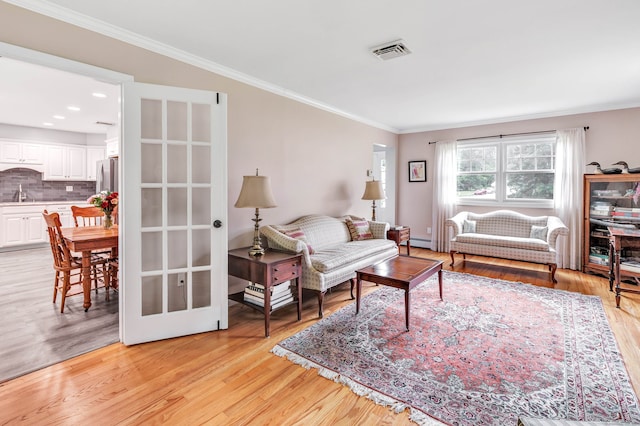 343 Steiner St, Fairfield, CT 06825 - living area with ornamental molding, light wood-type flooring, and a baseboard heating unit