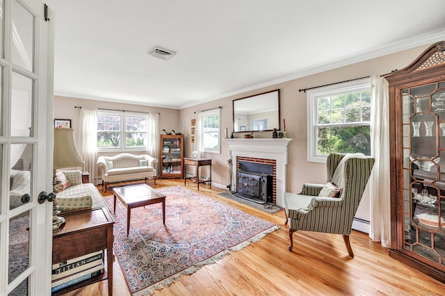 343 Steiner St, Fairfield, CT 06825 - living area with crown molding, wood finished floors, healthy amount of natural light, a brick fireplace, and a baseboard radiator