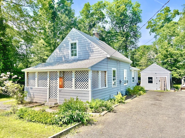 63 Fox Trl, Coventry, CT 06238 - view of front of house with a shingled roof, a chimney, and an outbuilding