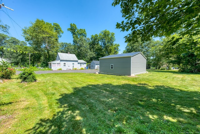 63 Fox Trl, Coventry, CT 06238 - view of green lawn with an outdoor structure and view of wooded area