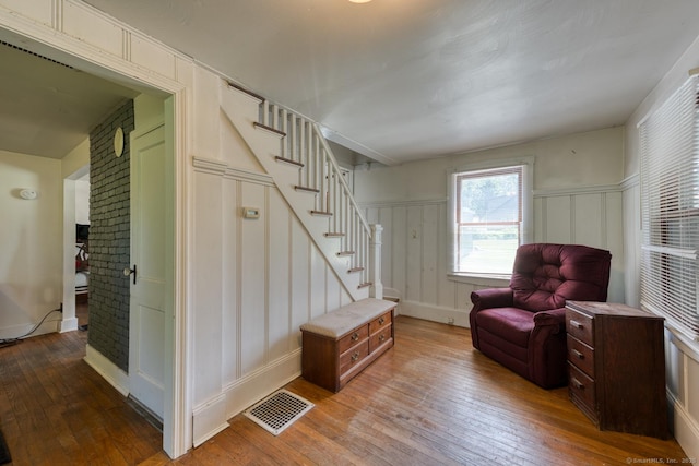 63 Fox Trl, Coventry, CT 06238 - living area with a decorative wall, hardwood / wood-style floors, stairs, a fireplace, and a wainscoted wall