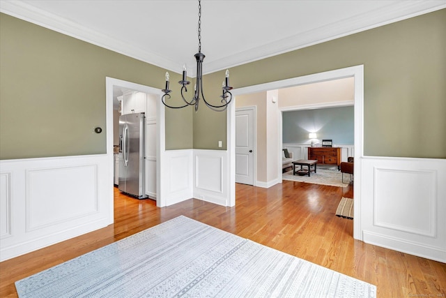 27 Bartlett Ln Unit 27, Shelton, CT 06484 - dining room with a chandelier, light wood-type flooring, ornamental molding, wainscoting, and a decorative wall