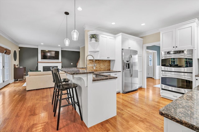 27 Bartlett Ln Unit 27, Shelton, CT 06484 - kitchen with stainless steel appliances, open shelves, a peninsula, crown molding, and white cabinetry