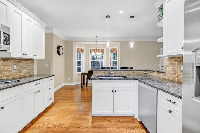 27 Bartlett Ln Unit 27, Shelton, CT 06484 - kitchen with stainless steel appliances, a peninsula, a chandelier, tasteful backsplash, and ornamental molding