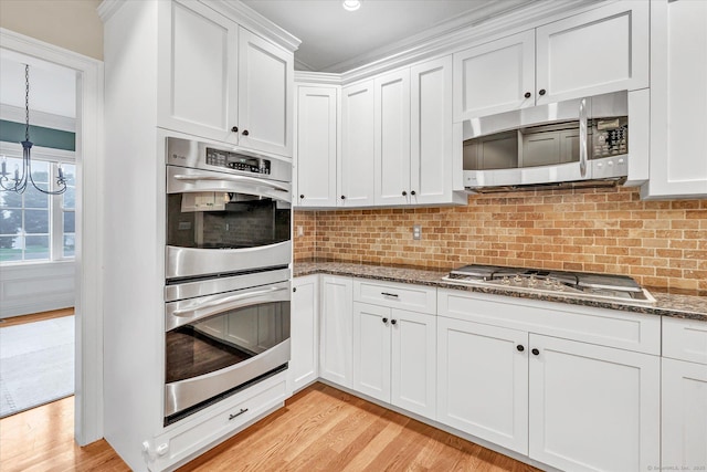 27 Bartlett Ln Unit 27, Shelton, CT 06484 - kitchen featuring appliances with stainless steel finishes, dark stone counters, white cabinets, and light wood-type flooring