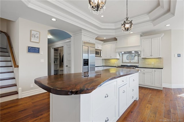 275 Chestnut Grv, Guilford, CT 06437 - kitchen with built in appliances, a chandelier, a raised ceiling, dark wood-style flooring, and crown molding