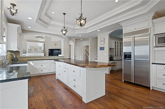 275 Chestnut Grv, Guilford, CT 06437 - kitchen with built in appliances, arched walkways, a chandelier, a raised ceiling, and ornamental molding