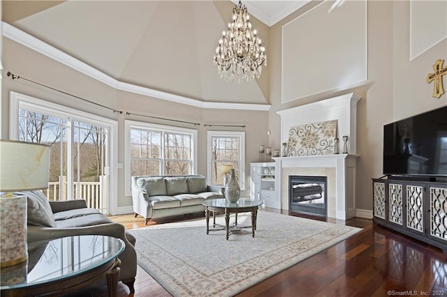 275 Chestnut Grv, Guilford, CT 06437 - living area featuring plenty of natural light, a towering ceiling, a chandelier, wood finished floors, and a glass covered fireplace