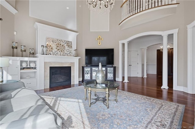 275 Chestnut Grv, Guilford, CT 06437 - living room with a high ceiling, wood finished floors, a glass covered fireplace, decorative columns, and arched walkways