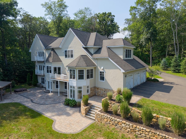 275 Chestnut Grv, Guilford, CT 06437 - rear view of house featuring a balcony, roof with shingles, and driveway