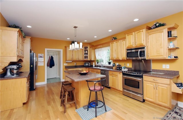 109 Davis Rd, Seymour, CT 06483 - kitchen with stainless steel appliances, a breakfast bar area, a center island, light wood-style floors, and a chandelier