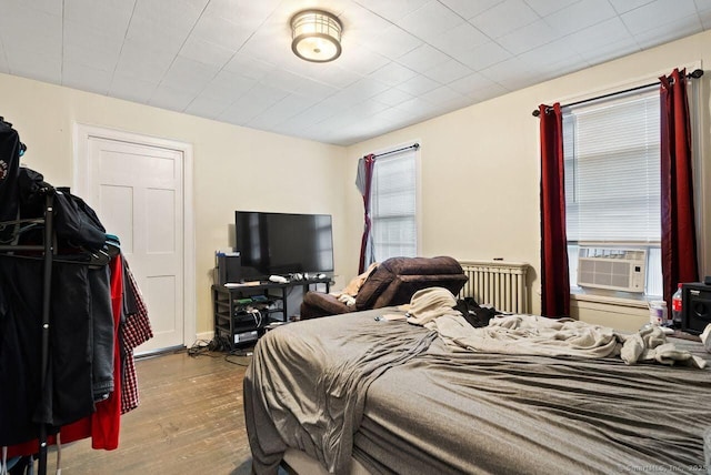 114 Prospect St, Norwich, CT 06360 - bedroom featuring cooling unit, wood finished floors, and radiator heating unit