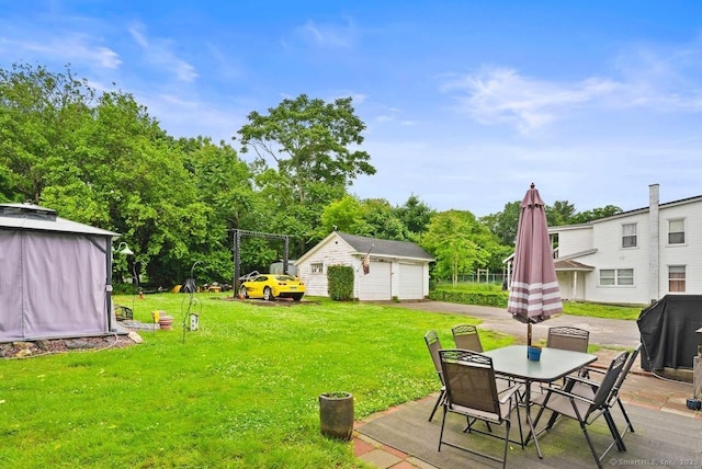 114 Prospect St, Norwich, CT 06360 - view of green lawn with an outbuilding, a detached garage, and outdoor dining space