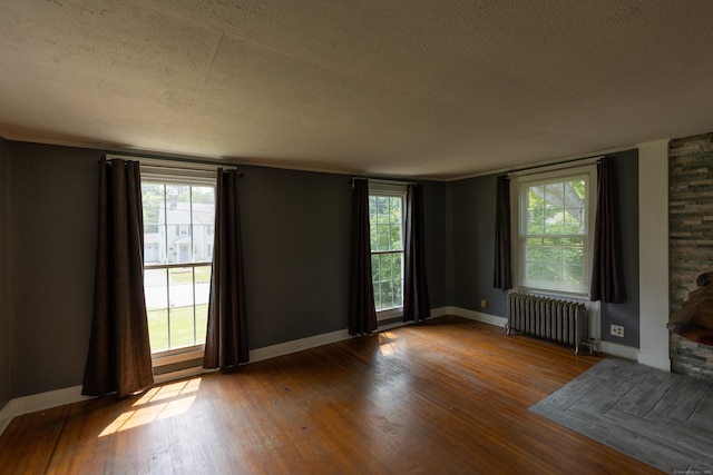 114 Spring St, Cheshire, CT 06410 - empty room with radiator, a textured ceiling, wood finished floors, and healthy amount of natural light