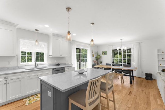 2 Sabrinas Ct, Norwich, CT 06360 - kitchen with dishwasher, white cabinets, a kitchen island, light wood-style flooring, and light stone counters