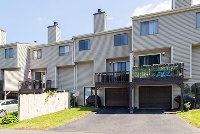 560 Yale Ave Unit 124, Meriden, CT 06450 - back of house featuring asphalt driveway, an attached garage, a chimney, and a balcony