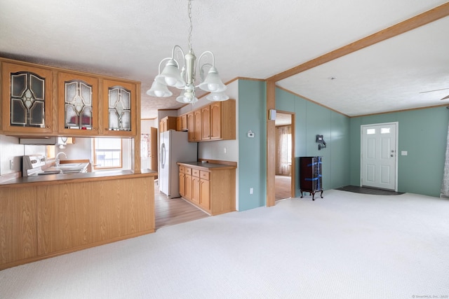 8 Haley Ln, Windham, CT 06256 - kitchen featuring freestanding refrigerator, a chandelier, lofted ceiling, light colored carpet, and glass insert cabinets