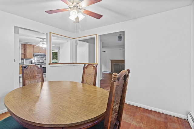 837 Long Cove Rd, Ledyard, CT 06335 - dining area featuring baseboard heating, a ceiling fan, wood finished floors, and a fireplace