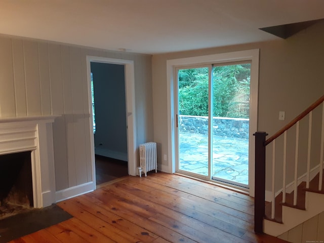 67 Hanover Rd, Newtown, CT 06470 - unfurnished living room with radiator, hardwood / wood-style flooring, and stairs