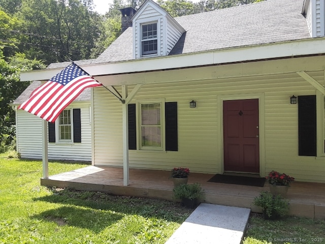 67 Hanover Rd, Newtown, CT 06470 - view of front of house featuring a front lawn, a shingled roof, a chimney, and covered porch