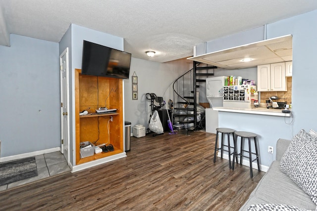 330 Short Beach Rd Apt G13, East Haven, CT 06512 - kitchen with dark wood-style flooring, a kitchen breakfast bar, white cabinetry, washer / dryer, and light countertops