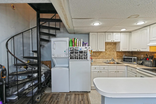 330 Short Beach Rd Apt G13, East Haven, CT 06512 - kitchen featuring stacked washer and clothes dryer, white appliances, white cabinetry, decorative backsplash, and light countertops