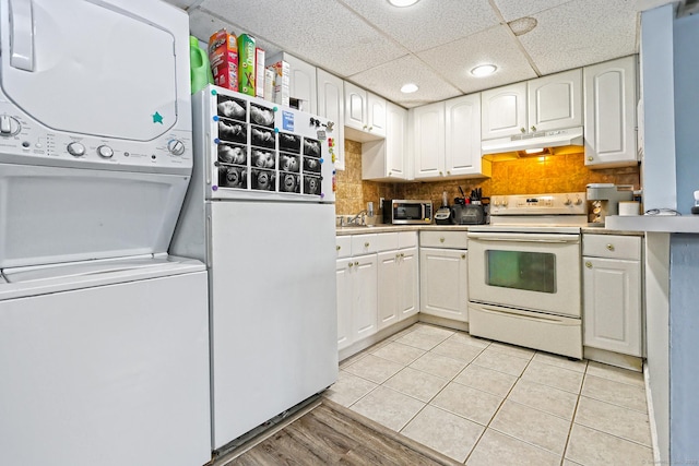 330 Short Beach Rd Apt G13, East Haven, CT 06512 - kitchen featuring white appliances, stacked washer and clothes dryer, under cabinet range hood, recessed lighting, and white cabinets