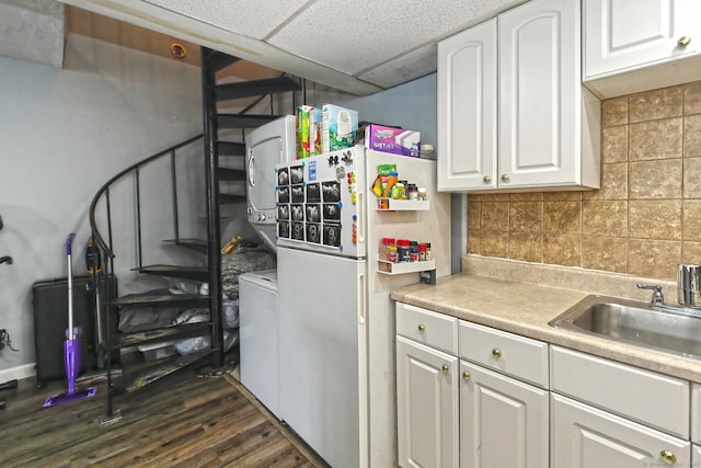 330 Short Beach Rd Apt G13, East Haven, CT 06512 - kitchen with estacked washer and dryer, freestanding refrigerator, white cabinetry, dark wood-style flooring, and a drop ceiling