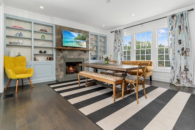 336 Ocean Dr W, Stamford, CT 06902 - dining space featuring dark wood-type flooring, built in shelves, a fireplace, crown molding, and recessed lighting