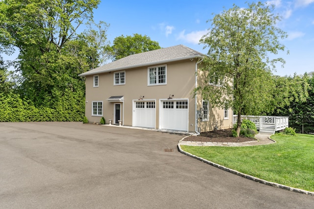 336 Ocean Dr W, Stamford, CT 06902 - view of front of home with an attached garage, driveway, stucco siding, a front lawn, and a deck