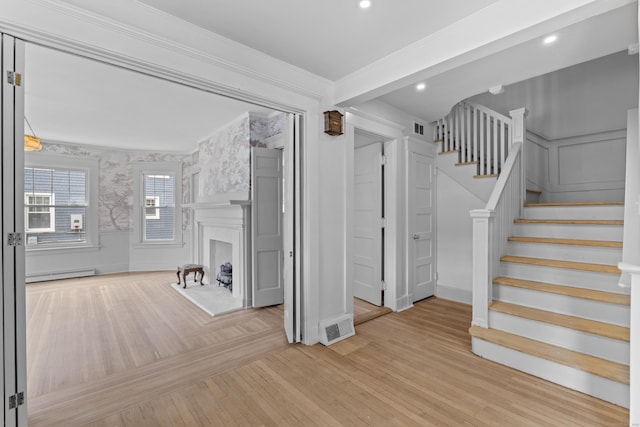 119 Westwood Rd, New Haven, CT 06515 - unfurnished living room with baseboard heating, stairs, a decorative wall, wood finished floors, and ornamental molding