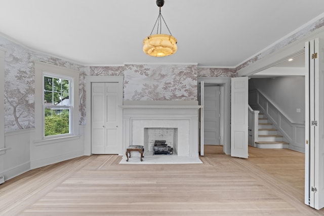 119 Westwood Rd, New Haven, CT 06515 - unfurnished living room featuring wallpapered walls, wainscoting, a fireplace with flush hearth, stairway, and crown molding