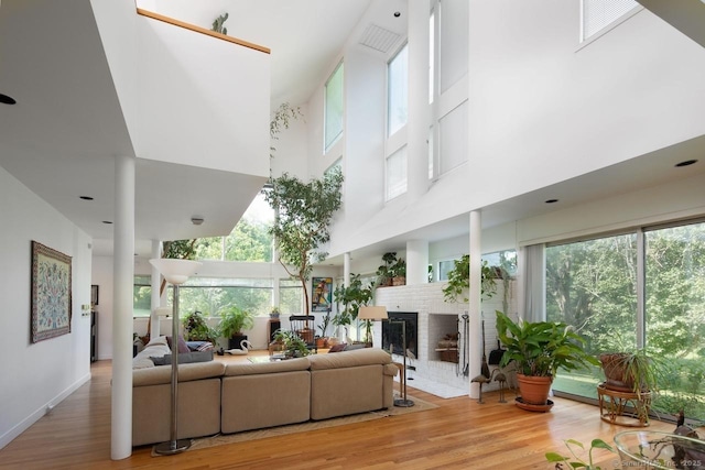 52 Cooper Hill Rd, Salisbury, CT 06068 - living room with a high ceiling, light wood-type flooring, plenty of natural light, and a fireplace