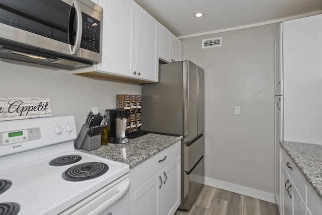 73 Landing Cir Unit 73, Suffield, CT 06078 - kitchen featuring appliances with stainless steel finishes, light wood-style flooring, white cabinets, recessed lighting, and light stone countertops