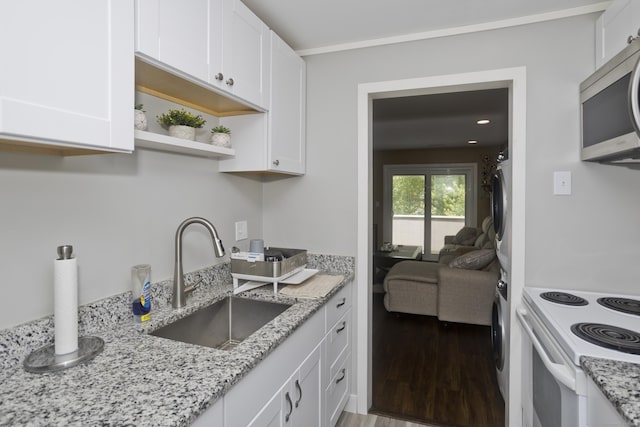 73 Landing Cir Unit 73, Suffield, CT 06078 - kitchen with estacked washer and dryer, stainless steel microwave, white cabinetry, wood finished floors, and recessed lighting