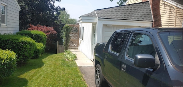 92 Sumac St, West Haven, CT 06516 - view of side of home featuring roof with shingles, a chimney, a lawn, and an attached garage