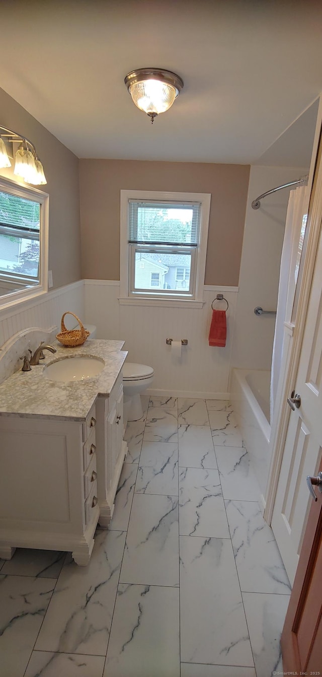 92 Sumac St, West Haven, CT 06516 - bathroom with wainscoting, vanity, marble look tiles, and shower / bath combo with shower curtain
