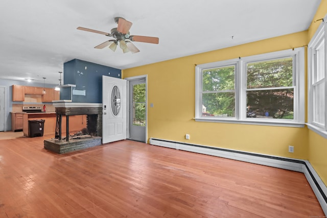 31 Richard Rd, Ledyard, CT 06335 - unfurnished living room with light wood finished floors, a ceiling fan, a baseboard radiator, and a stone fireplace