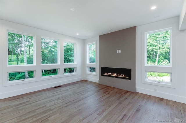 4B Vona Way, Newtown, CT 06470 - unfurnished living room with light wood finished floors, healthy amount of natural light, a fireplace, and recessed lighting