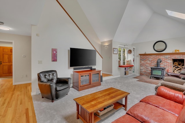 344 Oxbow Rd, Haddam, CT 06422 - living area with a wood stove, lofted ceiling, a skylight, light wood-style flooring, and light carpet