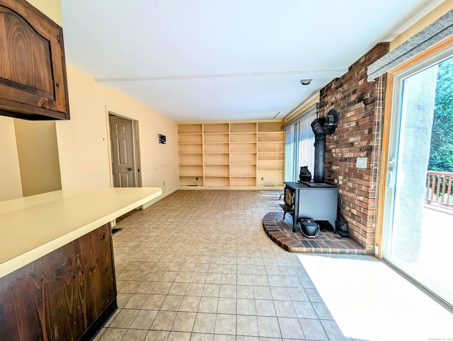 148A Westville Avenue Extension, Danbury, CT 06811 - unfurnished living room featuring a wood stove, built in shelves, and light tile patterned floors