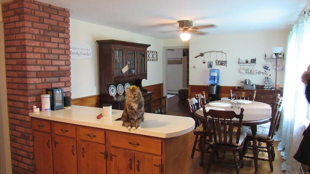 195 E Pearl St, Torrington, CT 06790 - kitchen with a peninsula, a ceiling fan, light countertops, wood finished floors, and brown cabinets