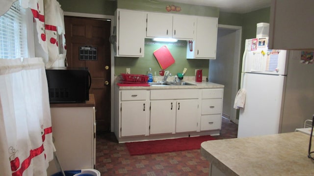 195 E Pearl St, Torrington, CT 06790 - kitchen with freestanding refrigerator, black microwave, white cabinetry, and light countertops