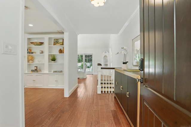 566 Hoyt St, Darien, CT 06820 - hall with an upstairs landing, light wood-style flooring, crown molding, and built in shelves