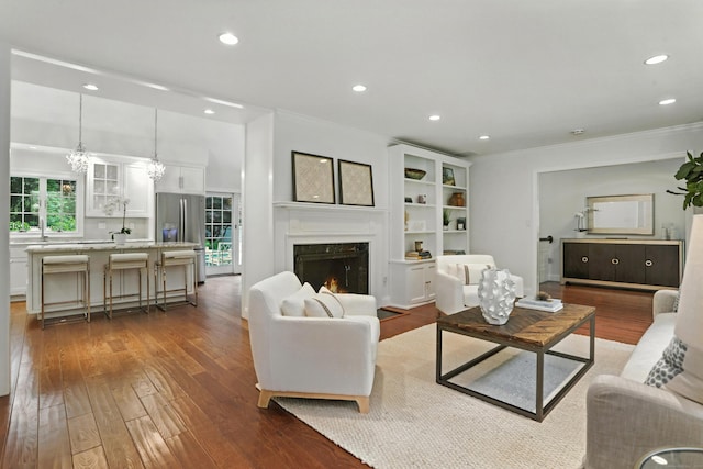 566 Hoyt St, Darien, CT 06820 - living area with crown molding, dark wood-style floors, recessed lighting, a premium fireplace, and a chandelier