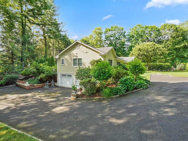 566 Hoyt St, Darien, CT 06820 - view of side of property with asphalt driveway and a garage