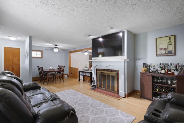 32 Butternut Ridge Rd, Waterbury, CT 06706 - living area featuring a ceiling fan, light wood-style floors, a brick fireplace, and a textured ceiling