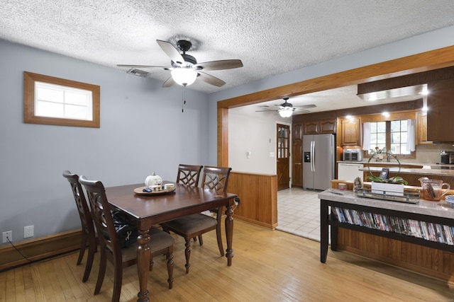 32 Butternut Ridge Rd, Waterbury, CT 06706 - dining room featuring ceiling fan, wainscoting, light wood-style flooring, a textured ceiling, and wood walls
