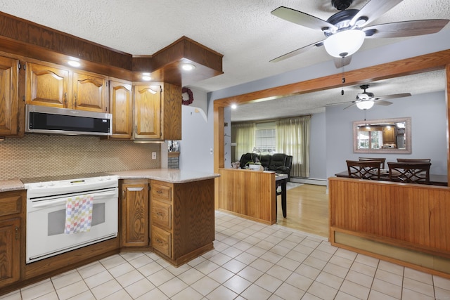 32 Butternut Ridge Rd, Waterbury, CT 06706 - kitchen featuring white range with electric cooktop, stainless steel microwave, a textured ceiling, open floor plan, and ceiling fan