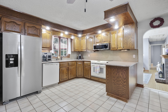32 Butternut Ridge Rd, Waterbury, CT 06706 - kitchen featuring appliances with stainless steel finishes, light countertops, a textured ceiling, decorative backsplash, and brown cabinets